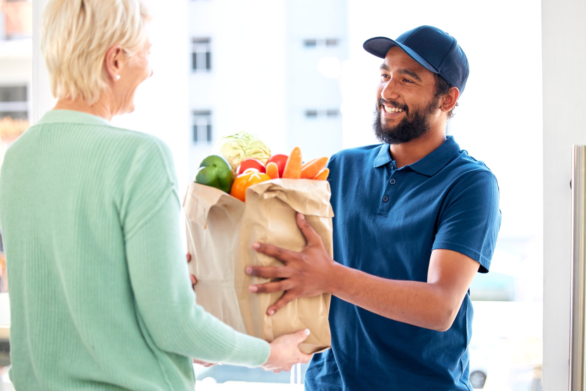 Delivery man, food and smile for customer, groceries and fresh produce from online shopping. Happy courier, supermarket discount and deal from supply chain, distribution with front door service.